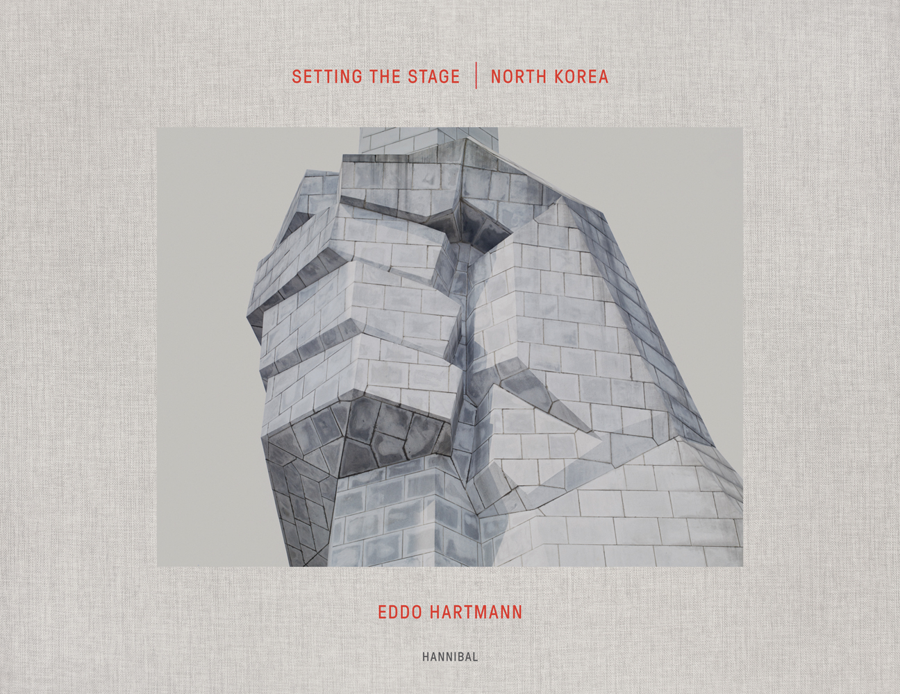 Drawing of fist with brickwork on pale grey cover of 'Setting the Stage: North Korea Eddo Hartmann', by Hannibal Books.