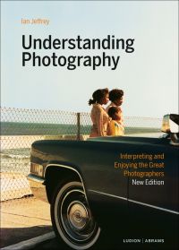 Book cover of Understanding Photography: Interpreting and Enjoying the Great Photographers, with a family standing near the front of a car, with the sea behind. Published by Ludion.