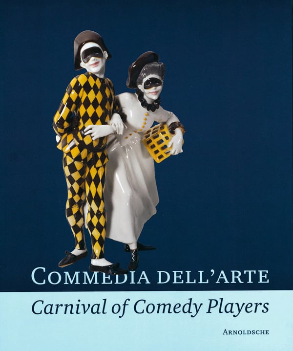 Porcelain figurine 'Pierrot and Pierrette', by Josef Wackerle, on navy cover of 'Commedia dell'Arte - Carnival of Comedy Players, Exquisite Ceramics from the World's Museums', by Arnoldsche Art Publishers.