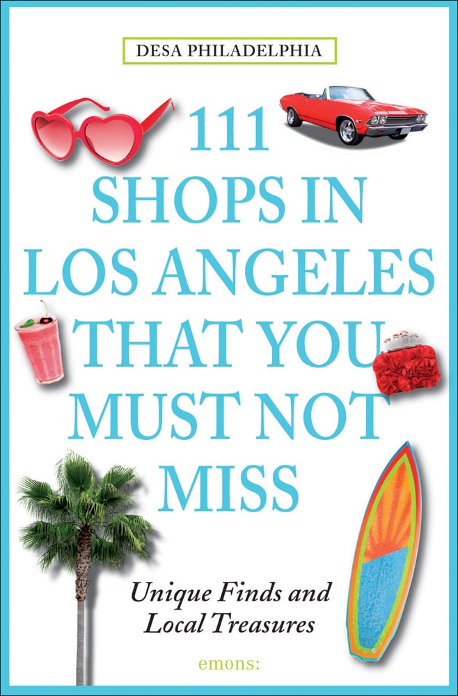 Pair of red heart-shaped sunglasses, pink smoothie, palm tree, surfboard, on white cover of '111 Shops in Los Angeles That You Must Not Miss', by Emons Verlag.