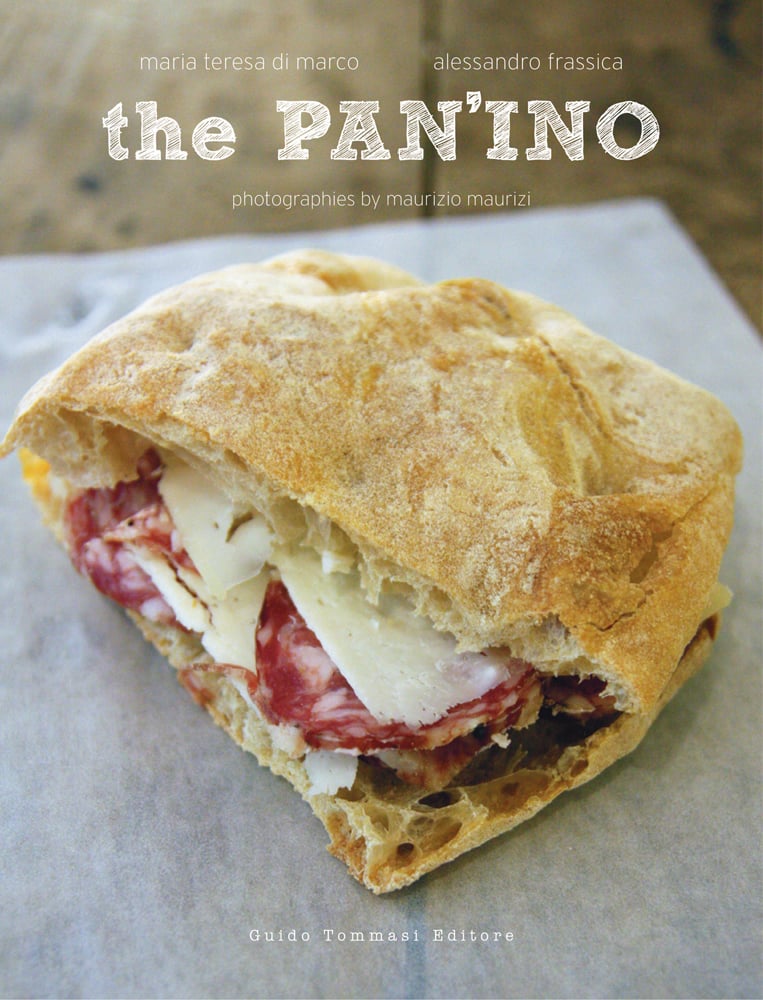 Italian sandwich with cheese and salami, on grease paper, the PAN'INO in stencilled cream font above