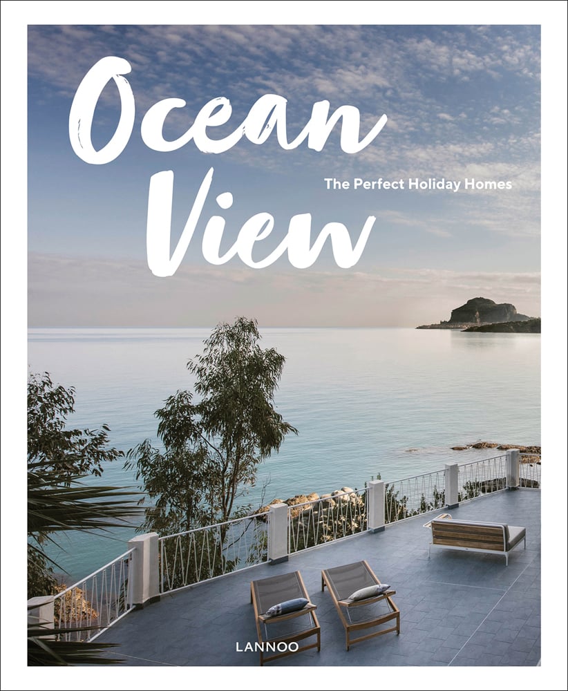 Stunning seascape view from holiday home with trees, deckchairs below, on cover of 'Ocean View, The Perfect Holiday Homes; Nature Retreats Vol. II', by Lannoo Publishers.