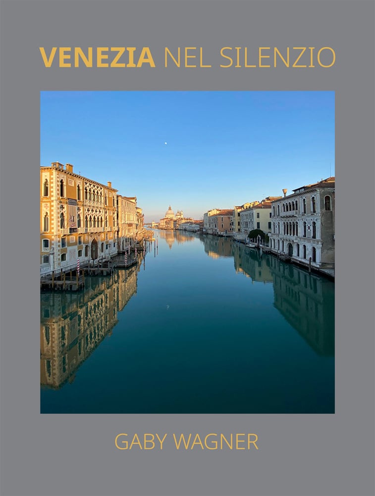Serene landscape photograph of Venice's canal, beneath blue sky, on grey cover of 'Venezia Nel Silenzio', by Ediciones El Viso.