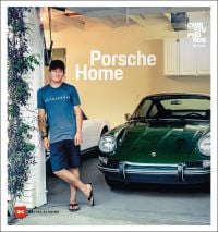 Man in t-shirt, shorts and flipflops leaning against brick garage with dark green Porsche inside, on cover of 'Porsche Home, Christophorus Edition', by Delius Klasing.