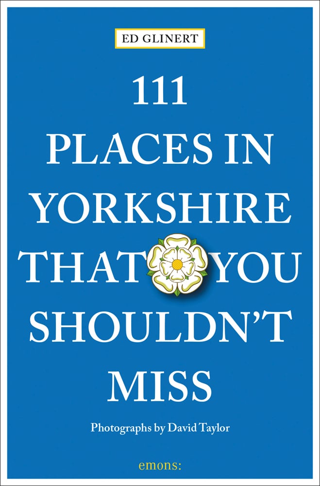 Yorkshire rose badge near centre of blue cover of '111 Places in Yorkshire That You Shouldn't Miss', by Emons Verlag.