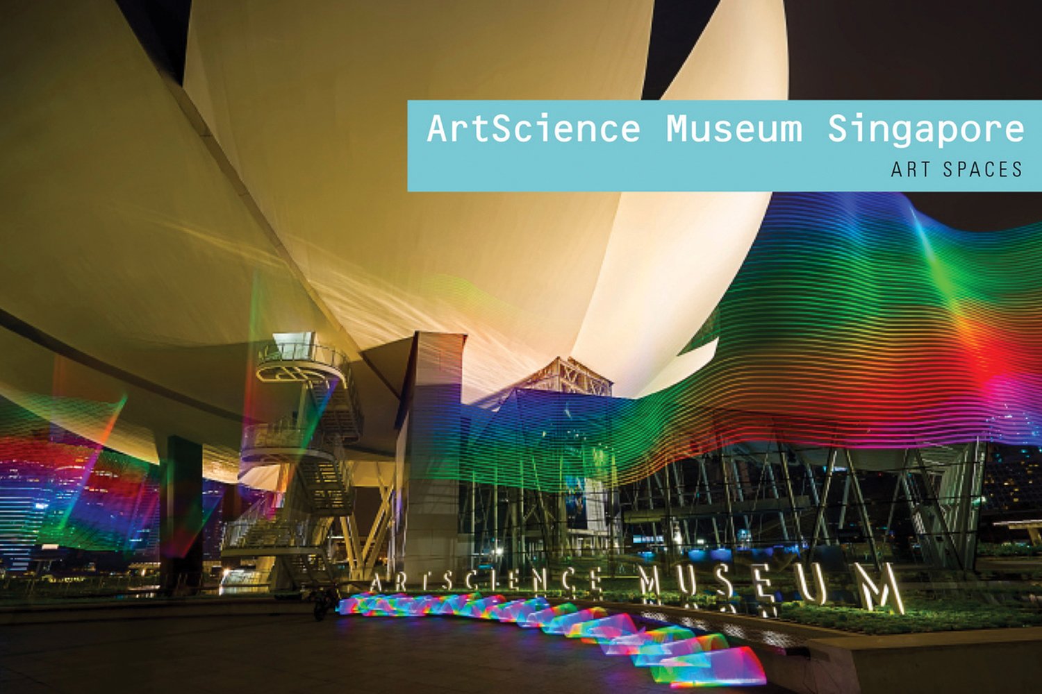 ArtScience Museum Singapore with wavy rainbow lights across cover, ArtScience Museum Singapore ART SPACES in white and black font on pale blue banner to upper right.