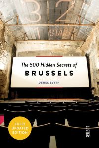 Cinema seat in a derelict theatre, looking at a white screen, on cover of 'The 500 Hidden Secrets of Brussels', by Luster Publishing.