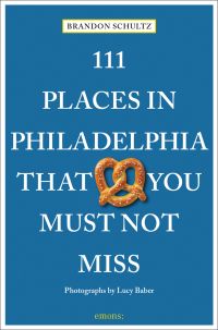Pretzel near centre of blue cover of '111 Places in Philadelphia That You Must Not Miss', by Emons Verlag.