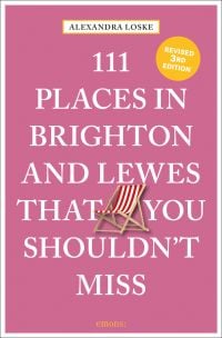 Red and white deckchair near center of pink cover of '111 Places in Brighton & Lewes That You Shouldn't Miss', by Emons Verlag.