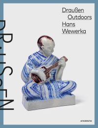Glazed ceramic figure of man cross-legged on floor, playing a guitar, on cover of 'Draußen Outdoors, Hans Wewerka, Stoneware Street Scenes / Straßenszenen in Steinzeug', by Arnoldsche Art Publishers.