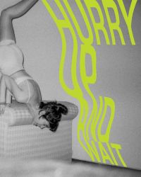 Book cover of Hurry Up and Wait, featuring female in underwear performing handstand on arm rest of sofa. Published by Verlag Kettler.