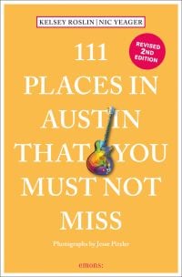 Rainbow coloured electric guitar near centre of peach cover of '111 Places in Austin That You Must Not Miss', by Emons Verlag.
