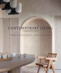 Interior with cream textured walls, with arched double doors, wooden chair and table, on cover of 'Contemporary Living Yearbook 2024', by Beta-Plus.