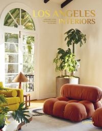 Book cover of Los Angeles Interiors, with an interior living room with a bulbous terracotta armchair, large pot plant in corner, arched doors looking out into garden. Published by Lannoo Publishers.