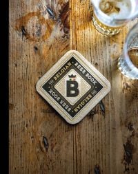 Book cover of The Belgian Beer Book, with a beer mat of table and two glasses of beer. Published by Lannoo Publishers.