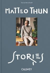 Book cover of Matteo Thun's Stories, with the architect sitting on a table, smiling while looking to his right. Published by Callwey.