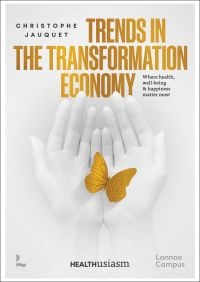 Book cover of Christophe Jauquet's Trends in the Transformation Economy: Where Health, Well-Being & Happiness Matter Most, with a pair of hands folding a gold butterfly. Published by Lannoo Publishers.