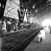 Book cover of Federico Garolla: Fotografie/Photographs 1948-1968, with a photograph of a busy train station, with a child sitting on suitcase. Published by Silvana.