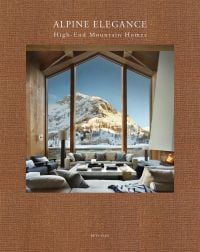 Book cover of Alpine Elegance: High-End Mountain Homes, featuring a cosy house with a view of snow topped mountains through the large windows. Published by Beta-Plus.