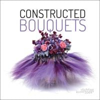 White cover of Constructed Bouquets, with floral arrangement of pink and purple flowers with a skirt of purple feathers to bottom. Published by Stichting.