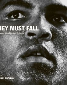 Book cover of They Must Fall, Muhammad Ali and the Men He Fought, Michael Brennan, featuring heavyweight champion Muhammad Ali with perspiration on face. Published by ACC Art Books.