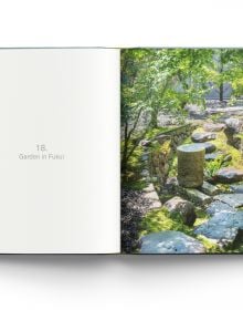 Book cover of Modern Japanese Gardens, with a Japanese garden with stones, pink blossom tree and small bridge. Published by ACC Art Books.