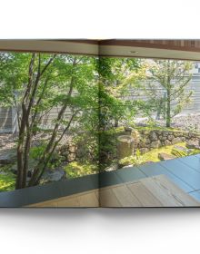 Book cover of Modern Japanese Gardens, with a Japanese garden with stones, pink blossom tree and small bridge. Published by ACC Art Books.