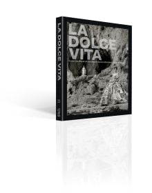 Book cover of La Dolce Vita: Inside the World of Dolce&Gabbana’s Alta Moda Fashion Shows, featuring a model in a large floral dress standing amongst a rocky mountain. Published by ACC Art Books.