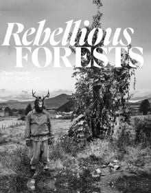 Book cover of Rebellious Forests, with a figure wearing a skeleton of animal on head, standing near a tree, with mountains behind. Published by Kulturalis.