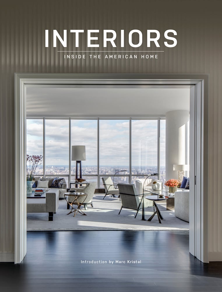 Book cover of Interiors Inside the American Home, feature a bright, open plan interior with pale furniture and large windows looking out onto cityscape, Published by Images Publishing.