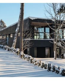 Book cover of Winter Homes: Stylish Living for Cool Climates, with a cabin obscured by snow-covered forest trees. Published by Images Publishing.