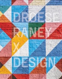 Brick wall painted with colourful triangular shapes, on cover of 'Droese Raney x Design', by ORO Editions.