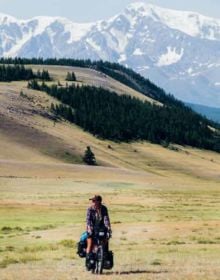 5 landscape photos of people on cycling trips across the world, on cover of '50 Ways to Cycle the World', by Lannoo Publishers.