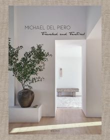 Book cover of Michael del Piero, with an doorway into a minimalist interior with white walls, pale wood floor, and a small tree in bronze pot. Published by Beta-Plus.