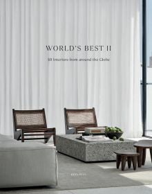 Book cover of World's Best II: 50 Interiors From Around the Globe, featuring a minimalist interior with marble table and long white drapes. Published by Beta-Plus.