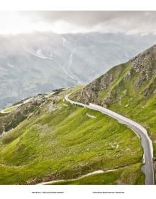 Hairpin bend in road with snow-topped mountains behind, on cover of 'Pass Portrait - Grossglockner, Austria 2504M', by Delius Klasing.