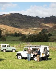 Front of Land Rover with driver, to centre of red heart, on white cover of 'Landy Love, Since 1948', by Delius Klasing.