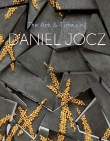 Book cover of The Art & Times of Daniel Jocz, featuring a grey shapes adorned with small gold beads. Published by Arnoldsche Art Publishers.