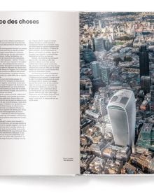 Low angled shot of aeroplane flying overhead London skyscrapers, white cover, streets of london, on black font above.