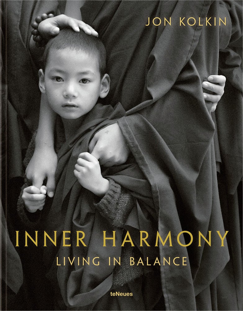 Book cover of Inner Harmony Living in Balance, featuring a child Buddhist in robes clutching hands of obscured figure. Published by teNeues Books.