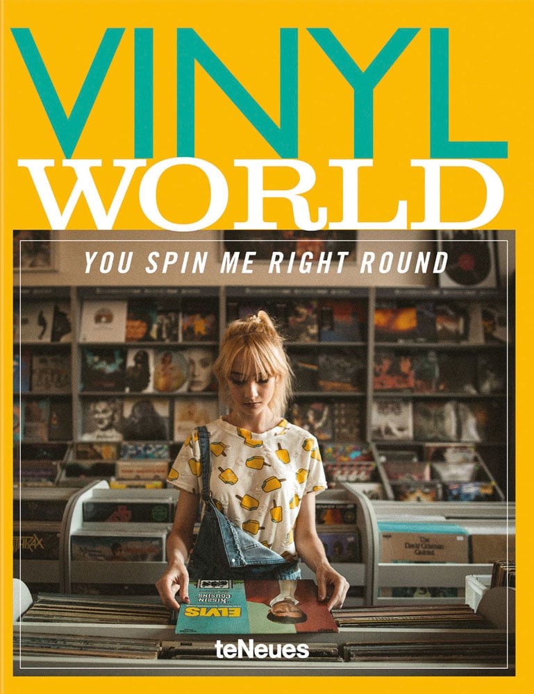 Book cover of Vinyl World: You Spin me Right Round, with a girl holding Elvis Presley record, while standing at shelving unit full of vinyl records. Published by teNeues Books.