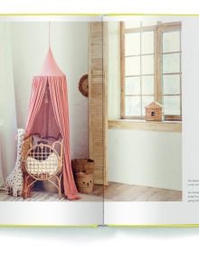 Large rattan chair draped with mustard coloured ceiling fabric, floppy hats on wall, on yellow cover of 'Boho Style, Bohemian Home Inspiration', by teNeues Books.