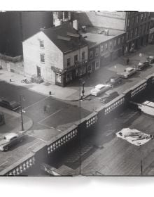 Man wearing white sailor's clothes and hat, with his back to viewer, staring across busy city street, on cover of 'Elliott Erwitt’s New York', by teNeues Books.