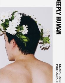 Book cover of Deeply Human: Global Queer Photography, with the back a male wearing a white flower headpiece. Published Verlag Kettler.