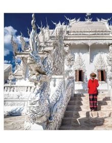 Book cover of 365 Meditations, A Spiritual Journey on the Path of Wisdom, with two young monks in red robes holding lit candles, sitting on a Buddha sculpture. Published by White Star.