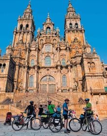 Book cover of Let's Bike!, The Best European Routes on Two Wheel, with a man standing with a pushbike looking towards a sunny mountain view. Published by White Star.