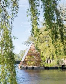 Book cover of 2018 Bruges Triennial: Liquid City, with a large red and yellow cocoon installation, floating on water with locks. Published by Stichting Kunstboek.