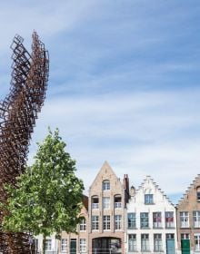 Book cover of 2018 Bruges Triennial: Liquid City, with a large red and yellow cocoon installation, floating on water with locks. Published by Stichting Kunstboek.