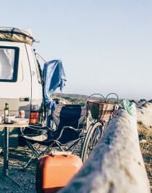 Book cover of Van Life: Culture, Vehicles, People, Places, with white and green camper van parked by the seaside, figure looking out to sea. Published by Lannoo Publishers.