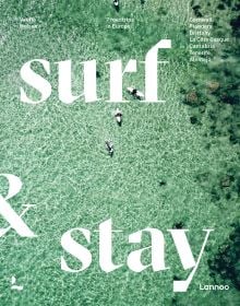 Aerial view of pale green sea with surfers on boards, on cover of 'Surf & Stay', by Lannoo Publishers.